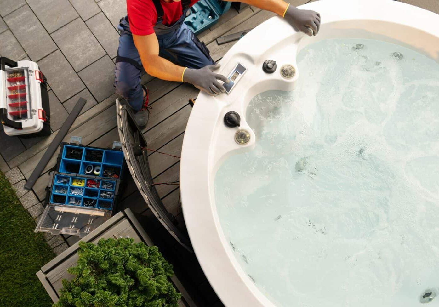 Professional Caucasian Hot Tub Technician Servicing Circular SPA Inside Residential Backyard Garden. Outdoor Bathtub Maintenance.